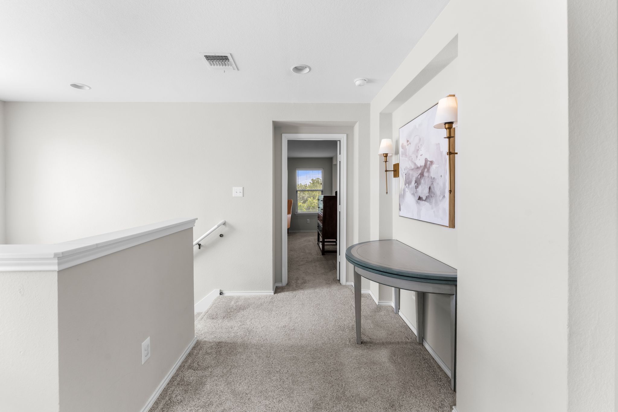 1133 Yellow Iris Road Leander, TX 78641 - Photo 35 of 37 Carpeted landing featuring a half-wall railing with white trim, recessed lighting, and an alcove with dual wall sconces