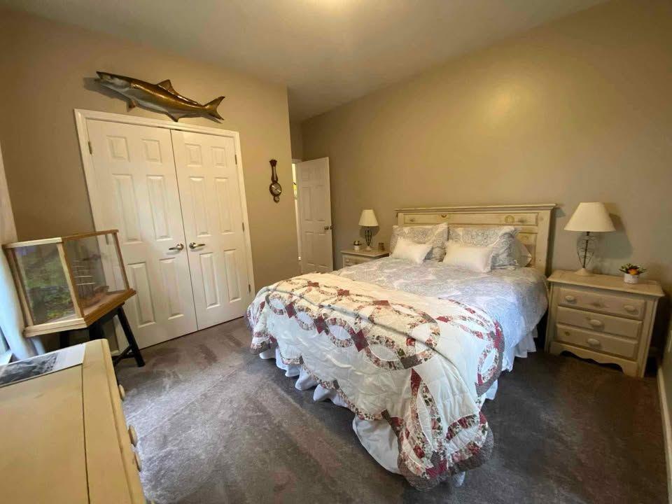 4005 South Apple Valley Road Commerce, GA 30529 - Photo 14 of 17 a bedroom with a bed a mirror on the dresser and a wooden floor
