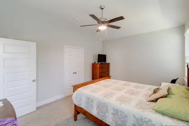 a bedroom with a bed and a ceiling fan