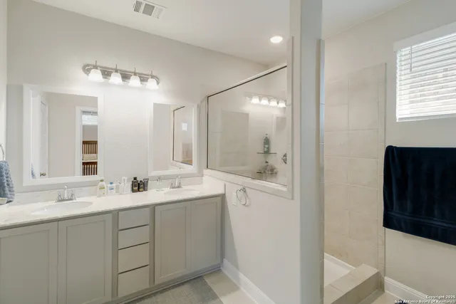 a bathroom with a double vanity sink a mirror and a bathtub