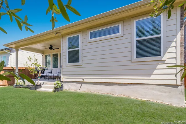 a view of a house with backyard and sitting area