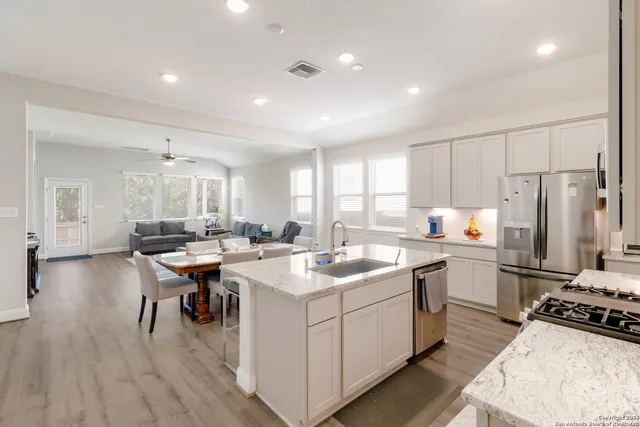 a kitchen with sink stove and chairs