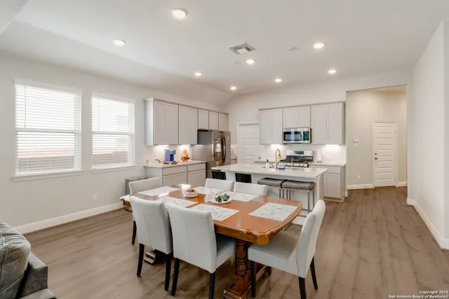 a dining room with a table chairs and a kitchen view