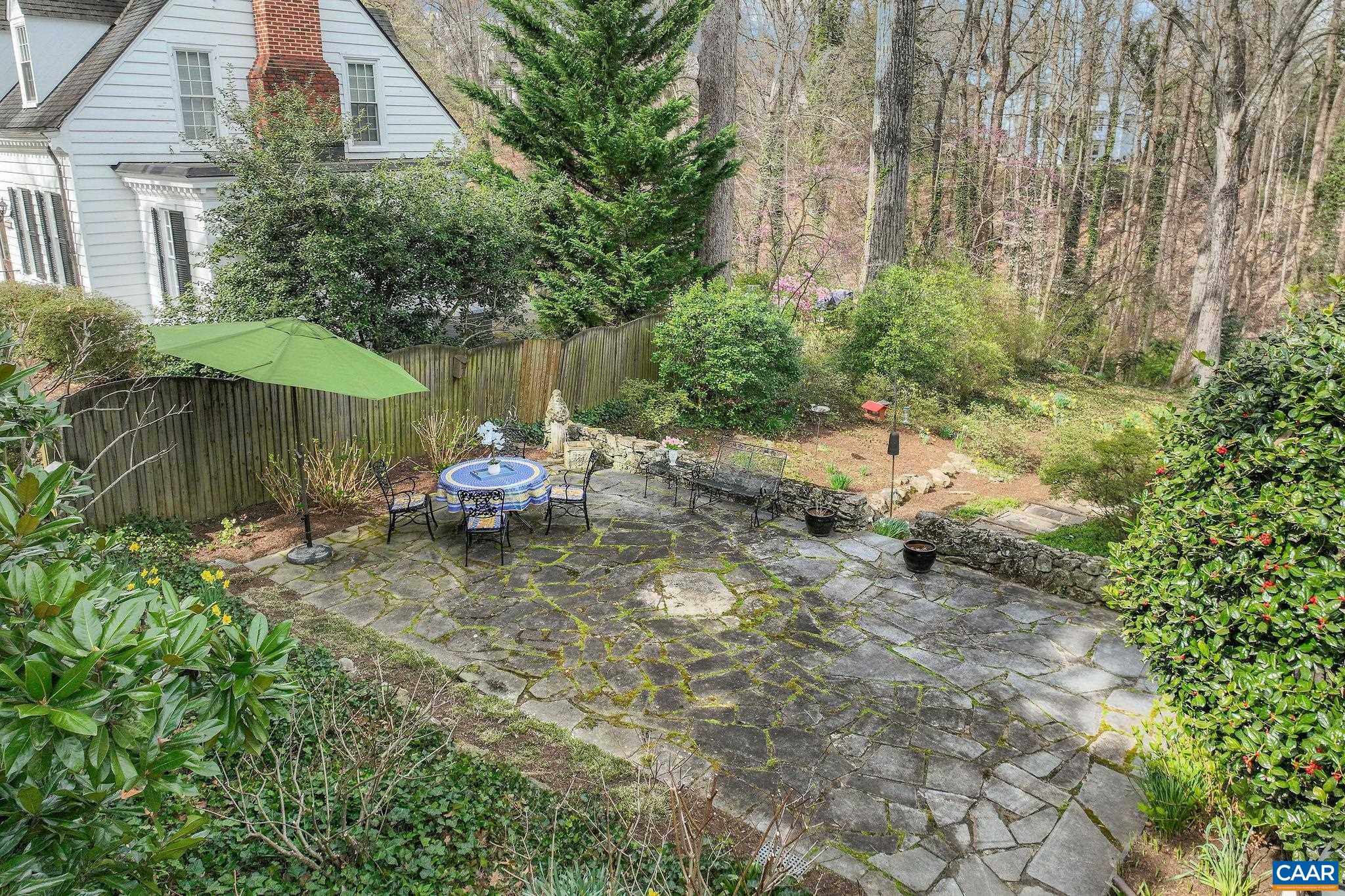 1335 Hilltop Road Charlottesville, VA 22903 - Photo 41 of 46 a backyard of a house with table and chairs under an umbrella