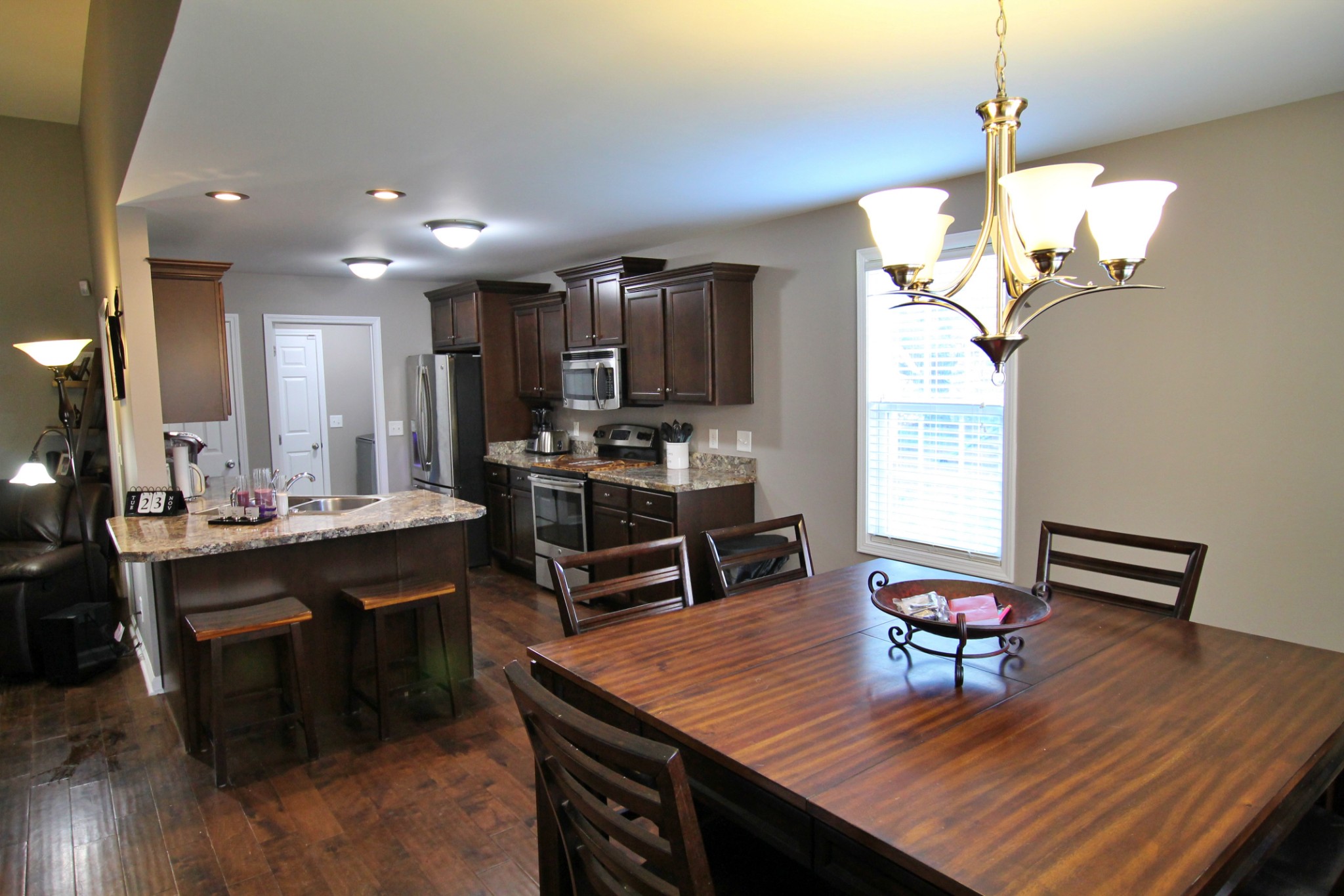 8005 New Chapel Road Springfield, TN 37172 - Photo 13 of 28 a view of a dining room and livingroom with furniture wooden floor a chandelier