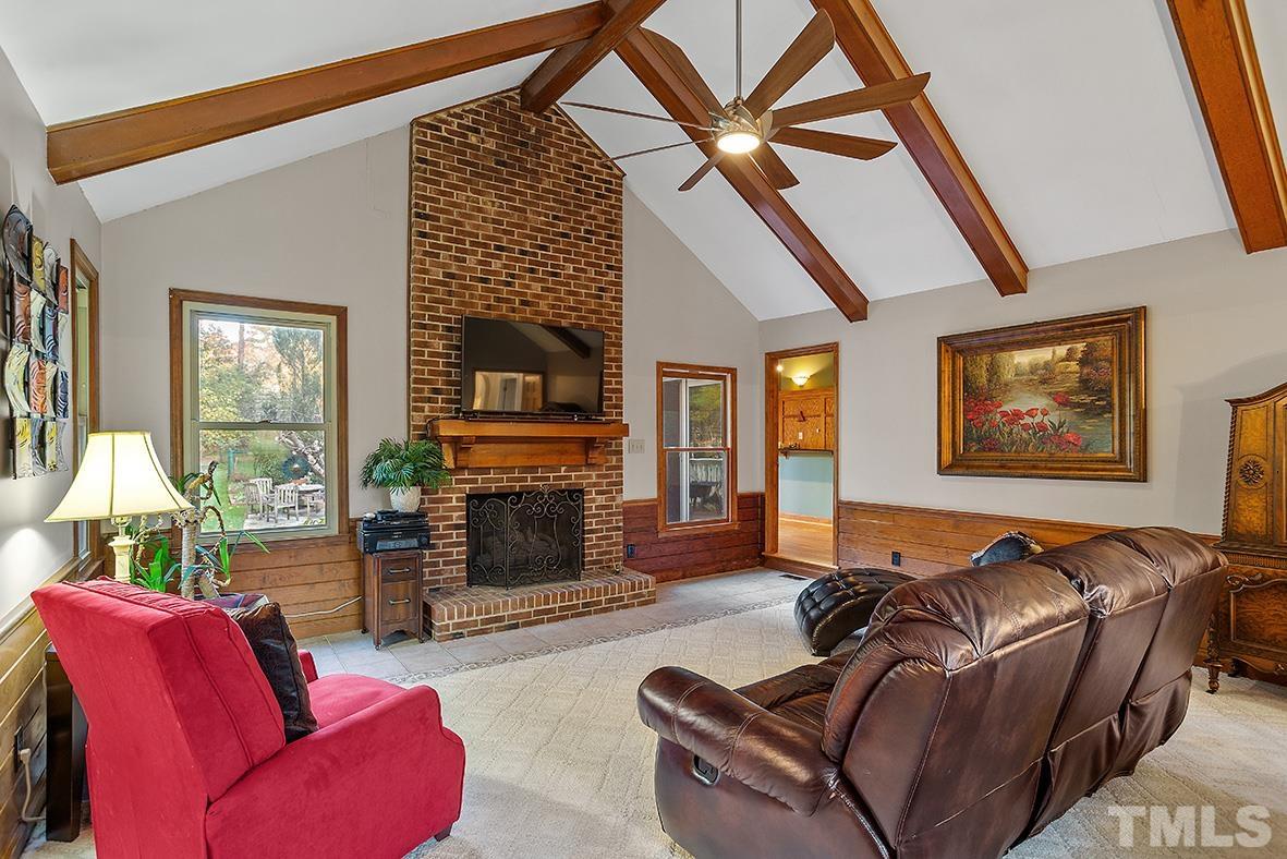 105 Carriage Trail Raleigh, NC 27614 - Photo 5 of 32 a living room with furniture a fireplace and a flat screen tv