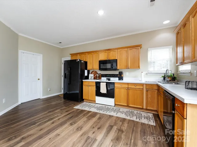a kitchen with granite countertop a refrigerator and wooden floor