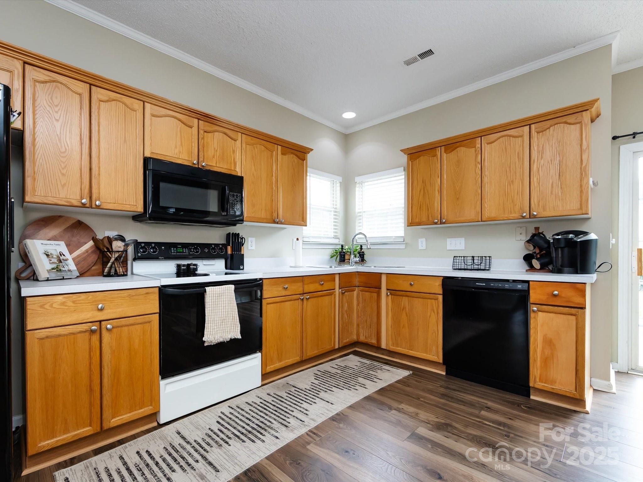 3910 Faith Church Road Indian Trail, NC 28079 - Photo 20 of 47 a kitchen with stainless steel appliances granite countertop wooden cabinets a stove top oven a sink and dishwasher with wooden floor