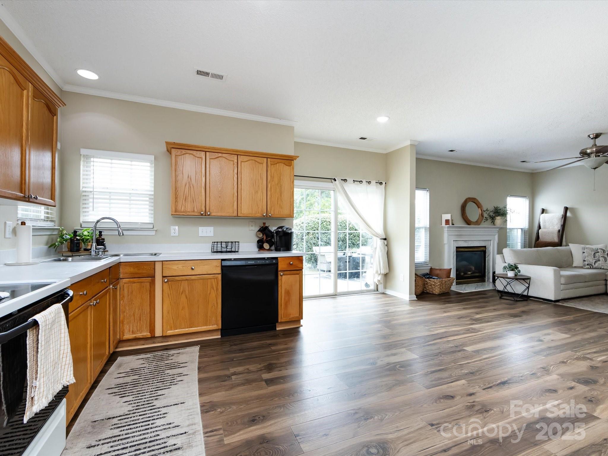 3910 Faith Church Road Indian Trail, NC 28079 - Photo 21 of 47 a large open kitchen with a refrigerator a stove a sink and a fireplace with wooden floor