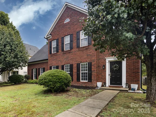 a view of a brick house with a large windows and a large tree