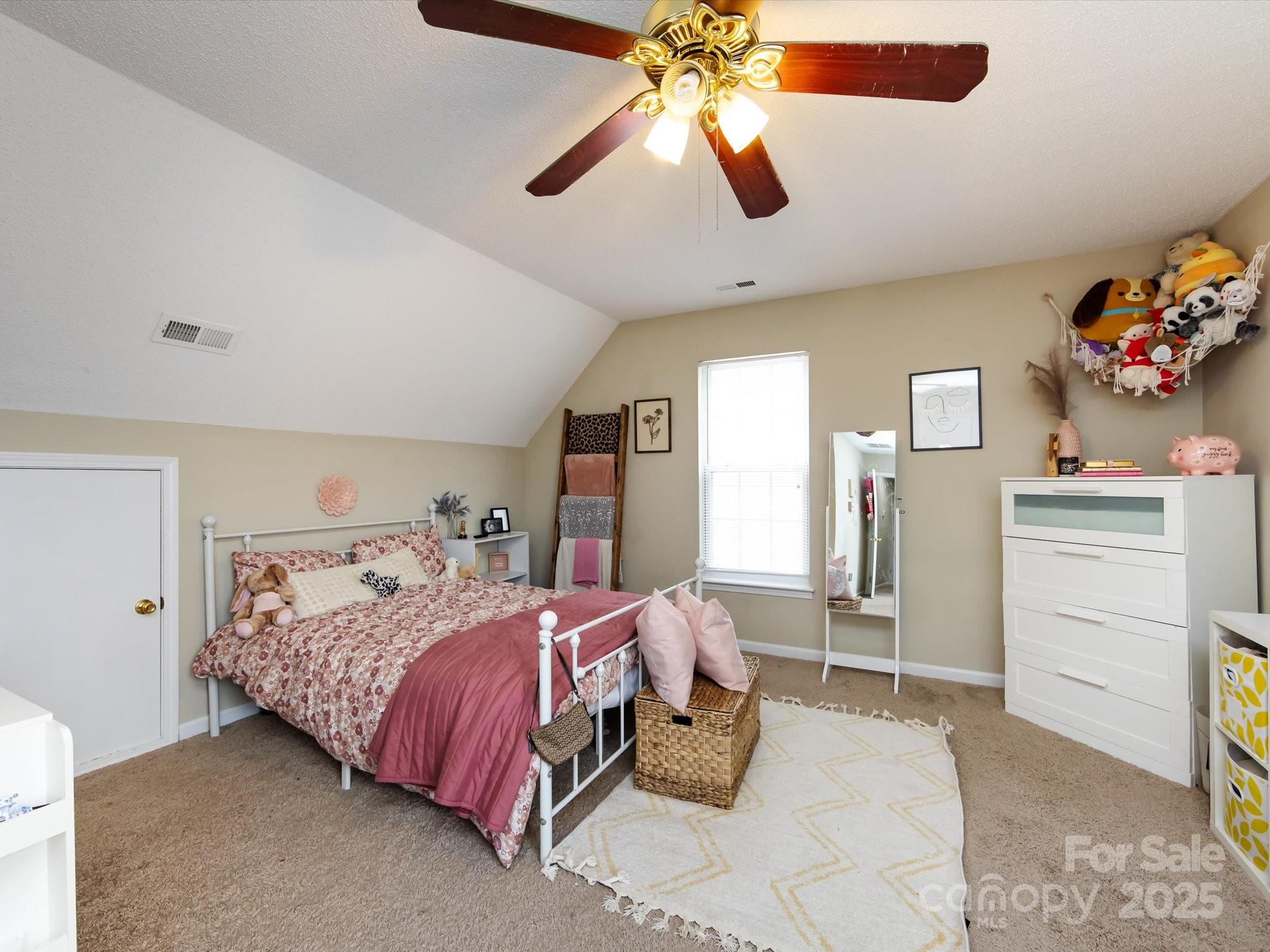 3910 Faith Church Road Indian Trail, NC 28079 - Photo 39 of 47 a bedroom with a bed and a chandelier