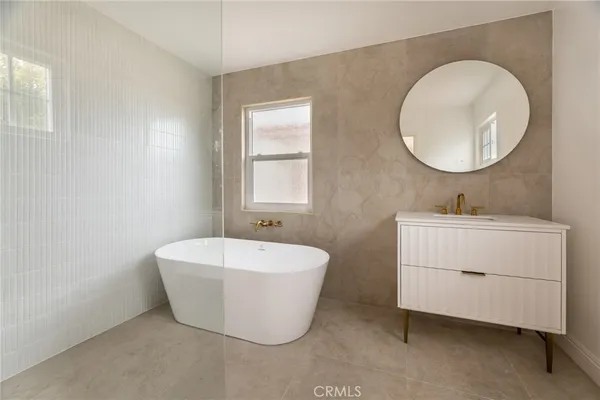 a spacious bathroom with a double vanity sink mirror and bathtub