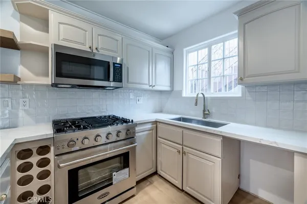 a kitchen with white cabinets stainless steel appliances and sink