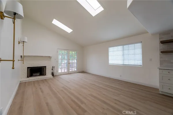 wooden floor fireplace and windows in an empty room
