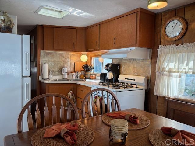 170 Diana Street, Unit 24 Encinitas, CA 92024 - Photo 13 of 26 a kitchen with stainless steel appliances granite countertop a refrigerator a stove a sink and a dining table with garden view
