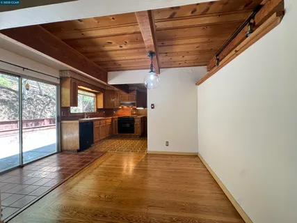 a view of kitchen with refrigerator and wooden floor