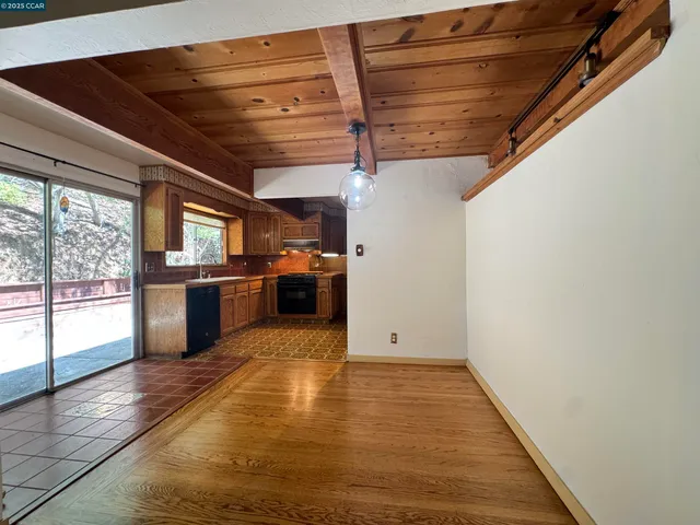 a view of kitchen with refrigerator and wooden floor