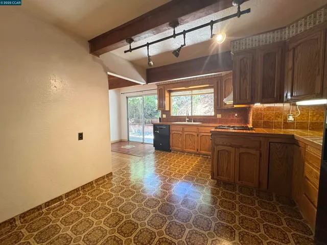 a kitchen with granite countertop a sink and a stove top oven