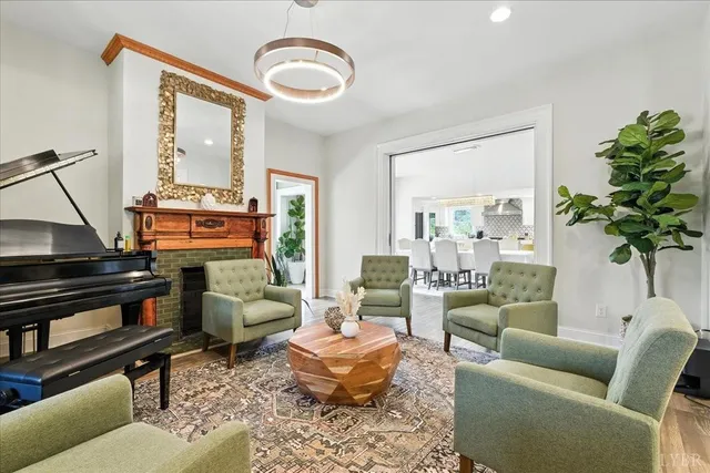 a kitchen with stainless steel appliances granite countertop a stove a sink a refrigerator and white cabinets with wooden floor