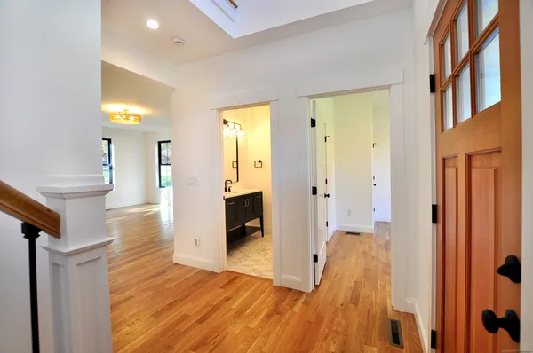 a view of a hallway with wooden floor windows and a living room