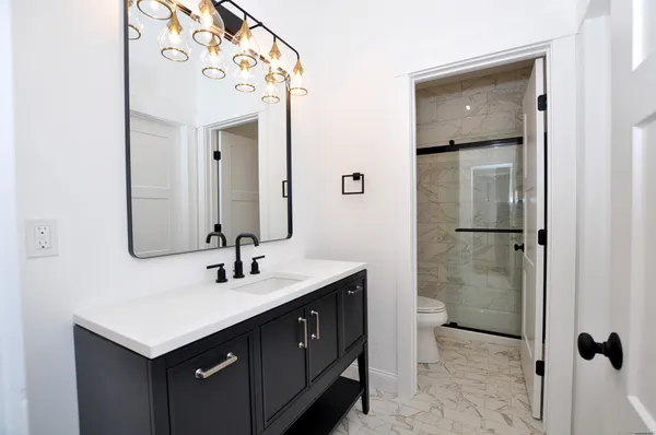 a bathroom with a sink mirror and shower