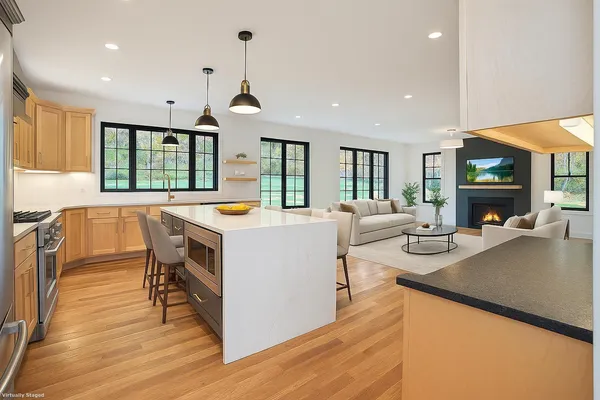 a living room with furniture a flat screen tv and a large window