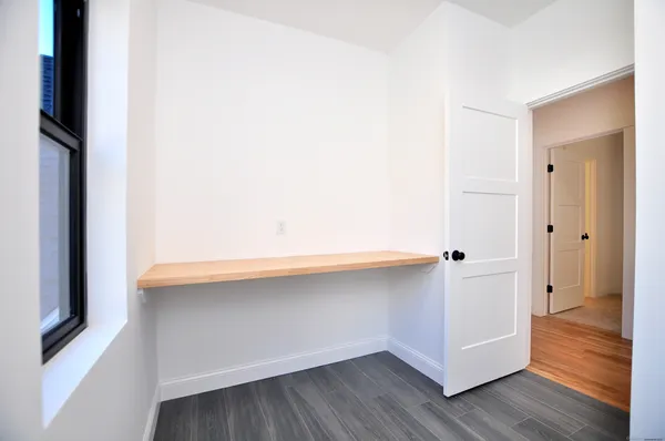 a room with wooden floor and white doors
