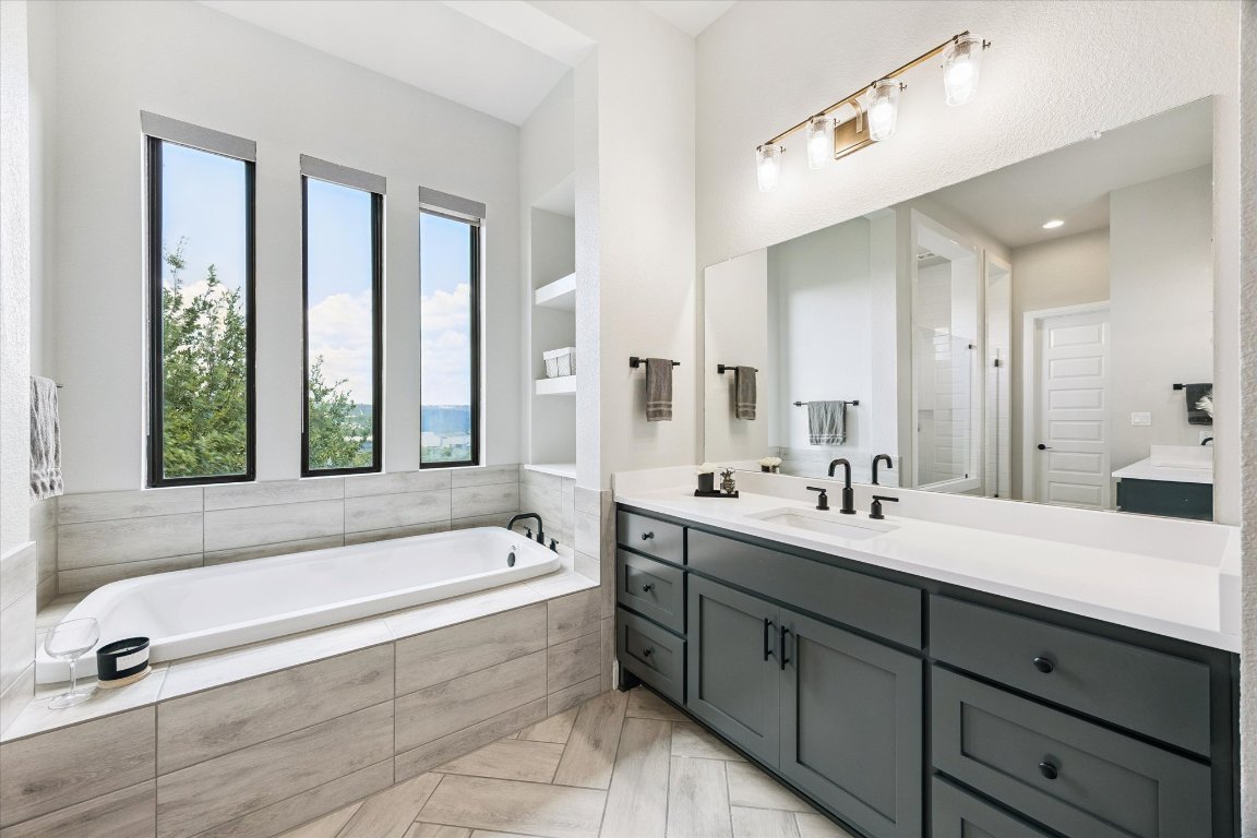 2113 Normandy View Leander, TX 78641 - Photo 11 of 23 a spacious bathroom with a double vanity sink a mirror and a bathtub