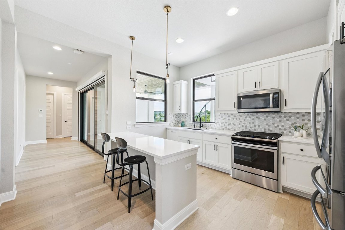 2113 Normandy View Leander, TX 78641 - Photo 19 of 23 a kitchen with a stove a sink and a microwave