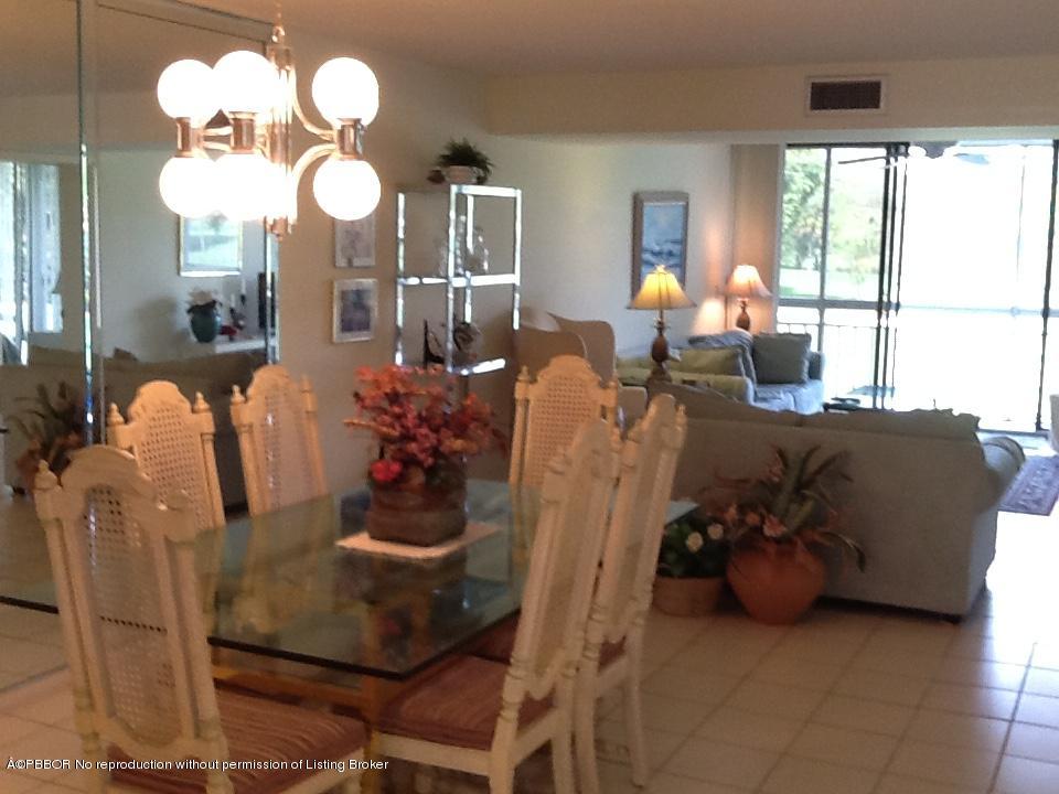 6157 Balboa Circle, Unit 206 Boca Raton, FL 33433 - Photo 12 of 31 a view of a dining room with furniture a chandelier and large windows