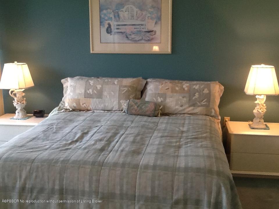 6157 Balboa Circle, Unit 206 Boca Raton, FL 33433 - Photo 22 of 31 a bedroom with a bed and a lamp