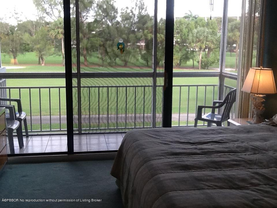 6157 Balboa Circle, Unit 206 Boca Raton, FL 33433 - Photo 23 of 31 a bedroom with a bed and large window