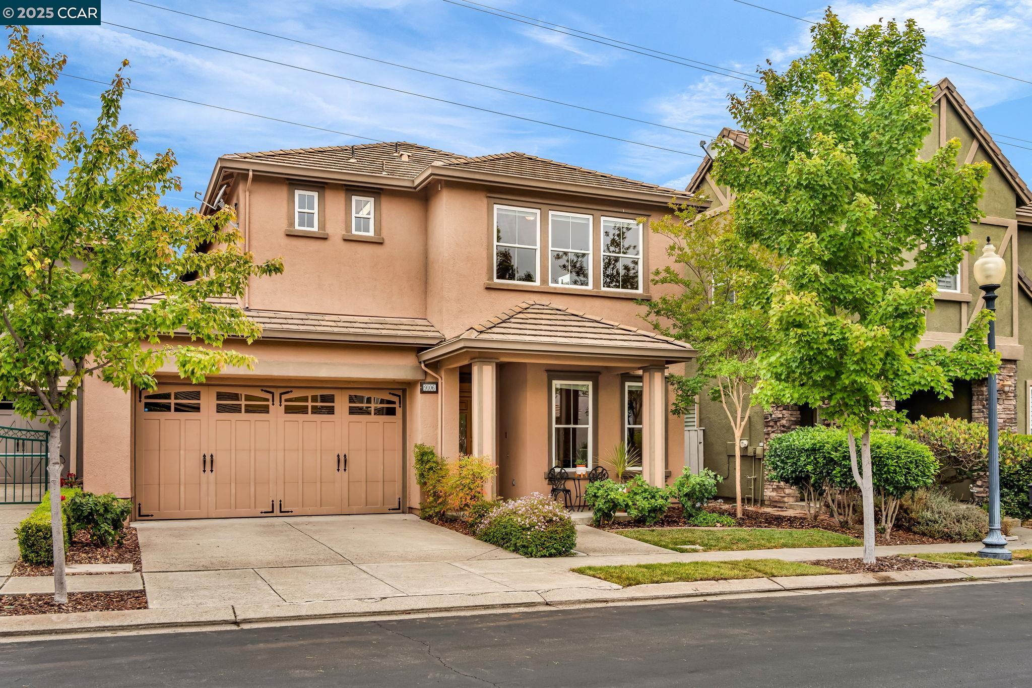 a front view of a house with a yard garage and outdoor seating