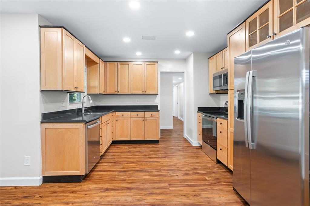 516 Baxter Street Orlando, FL 32806 - Photo 8 of 40 a large kitchen with stainless steel appliances granite countertop a stove a sink and a refrigerator