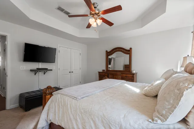 a bedroom with a bed and a flat tv screen on dresser
