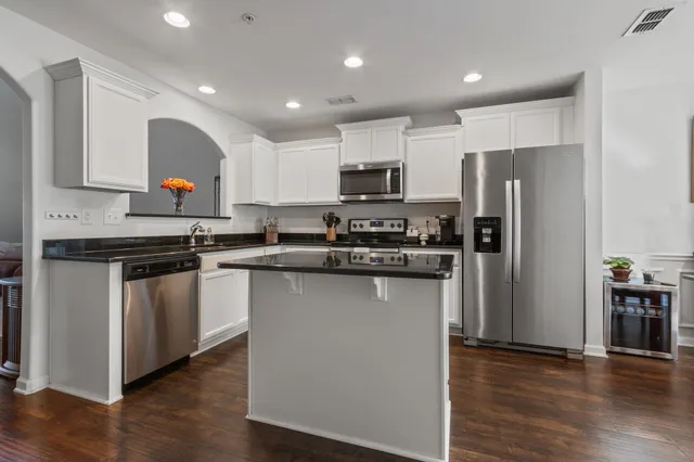 a kitchen with stainless steel appliances granite countertop a refrigerator and a stove top oven