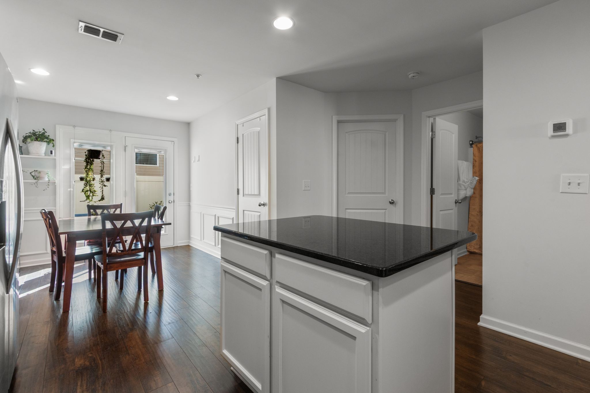 1002 Muna Court Spring Hill, TN 37174 - Photo 7 of 28 a kitchen with granite countertop kitchen island stainless steel appliances a table chairs sink and wooden floor