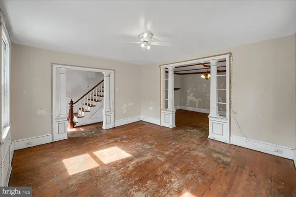 a view of an empty room with stairs and a window