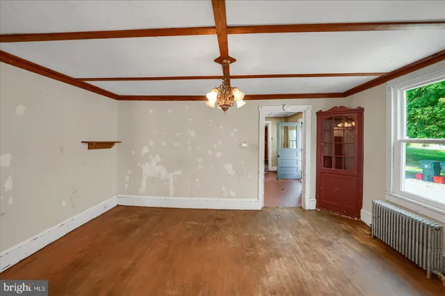 a view of a big room with windows and chandelier fan