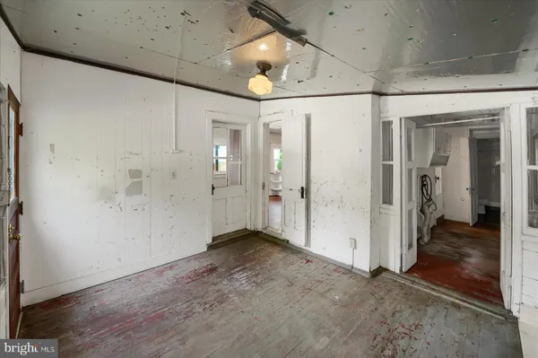 a view of a hallway with wooden floor and closet area