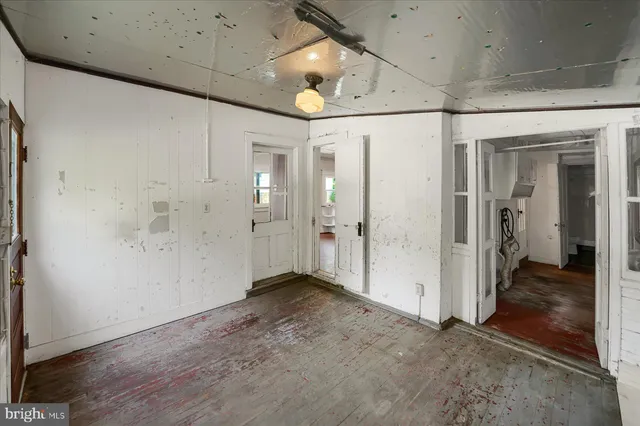 a view of a hallway with wooden floor and closet area