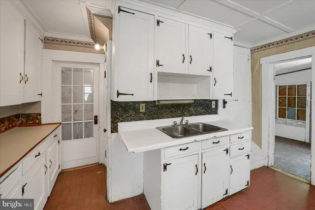a kitchen with white cabinets and white appliances