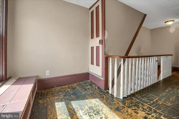 a balcony with wooden floor and fence next to a yard