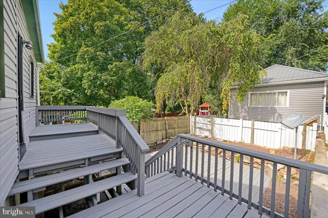 a view of a house with a small yard and wooden deck