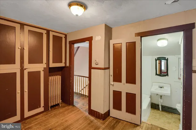 a view of front door with hallway and wooden floor