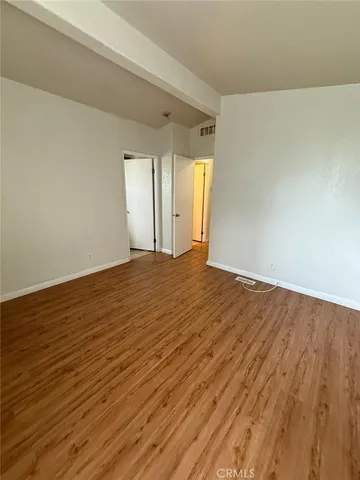 a view of an empty room and wooden floor