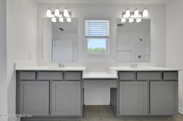 a bathroom with a sink double vanity and a shower