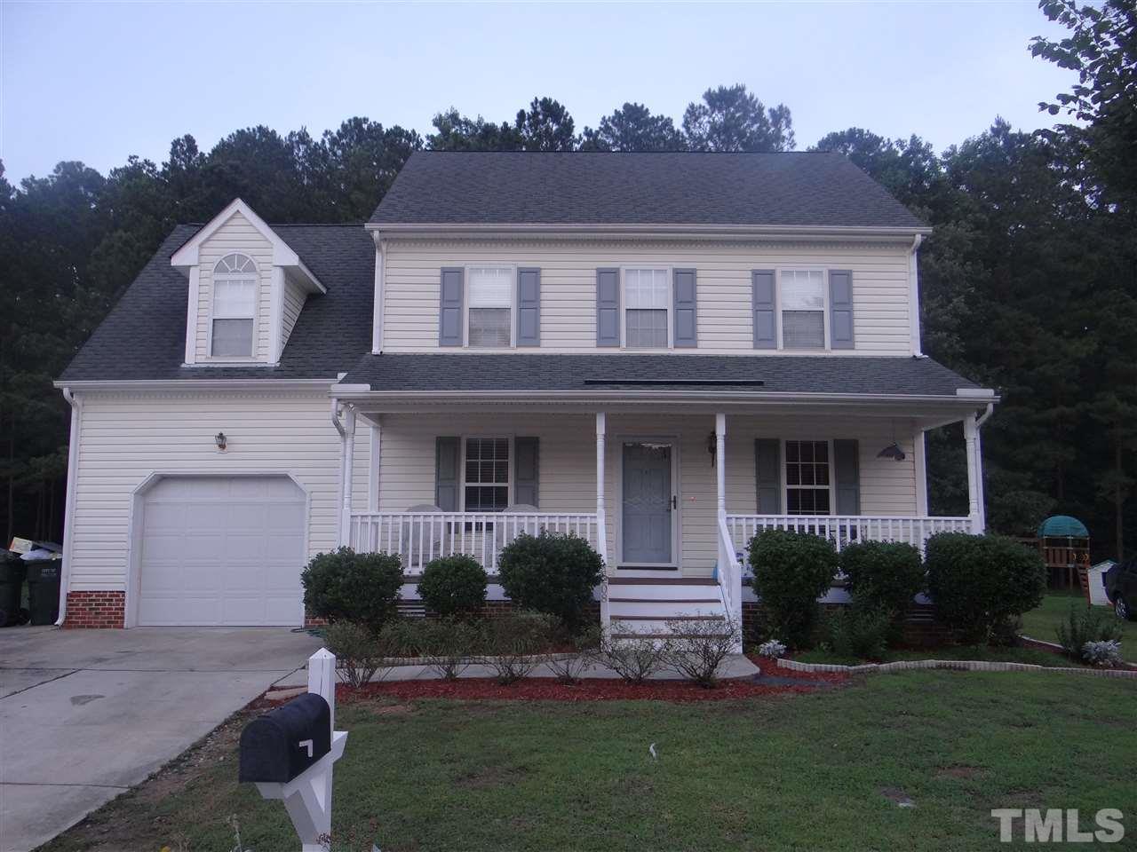 a front view of a house with a garden and plants