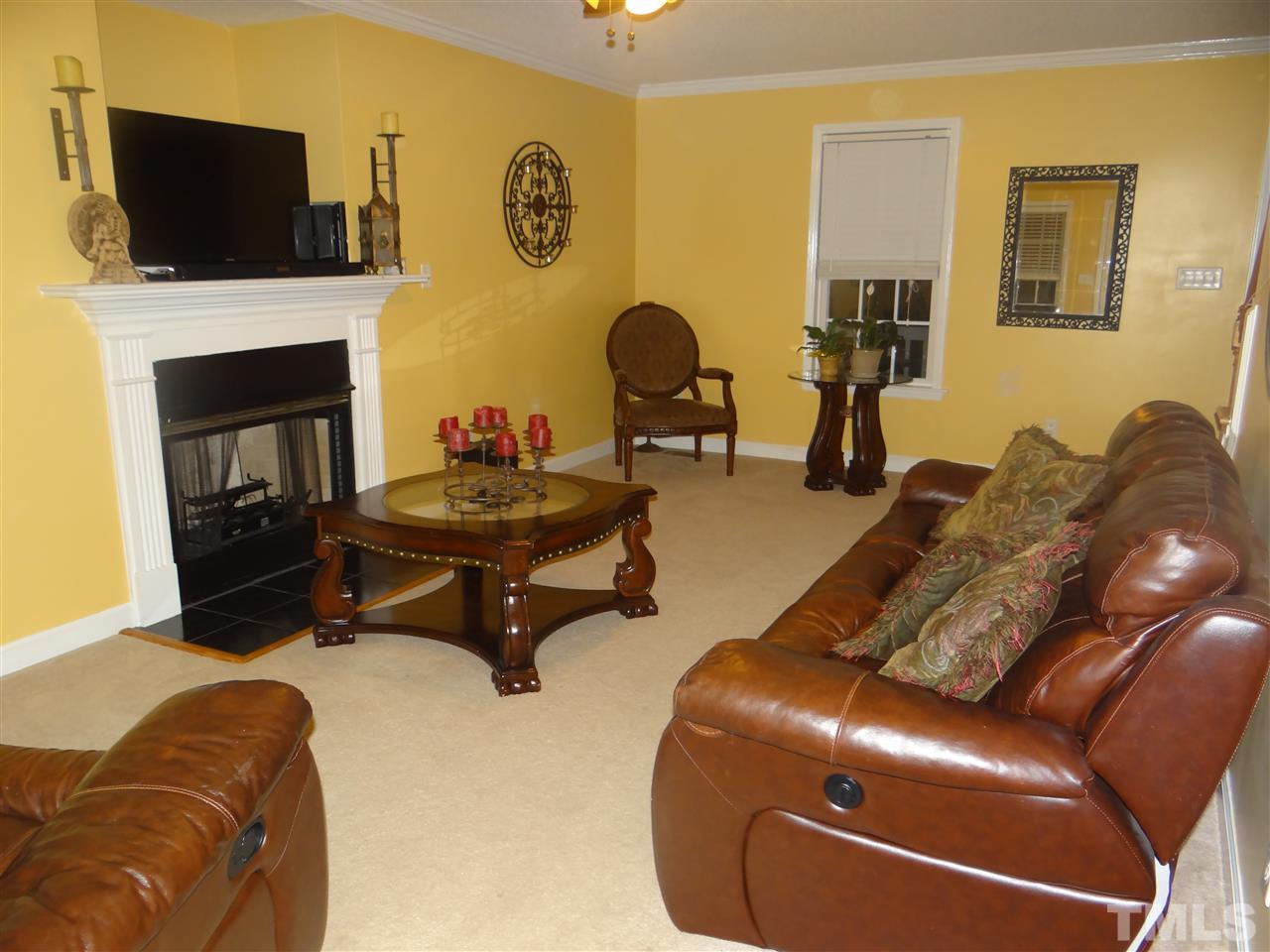 4208 Wolftrap Road Raleigh, NC 27616 - Photo 12 of 23 a living room with furniture a flat screen tv and a fireplace