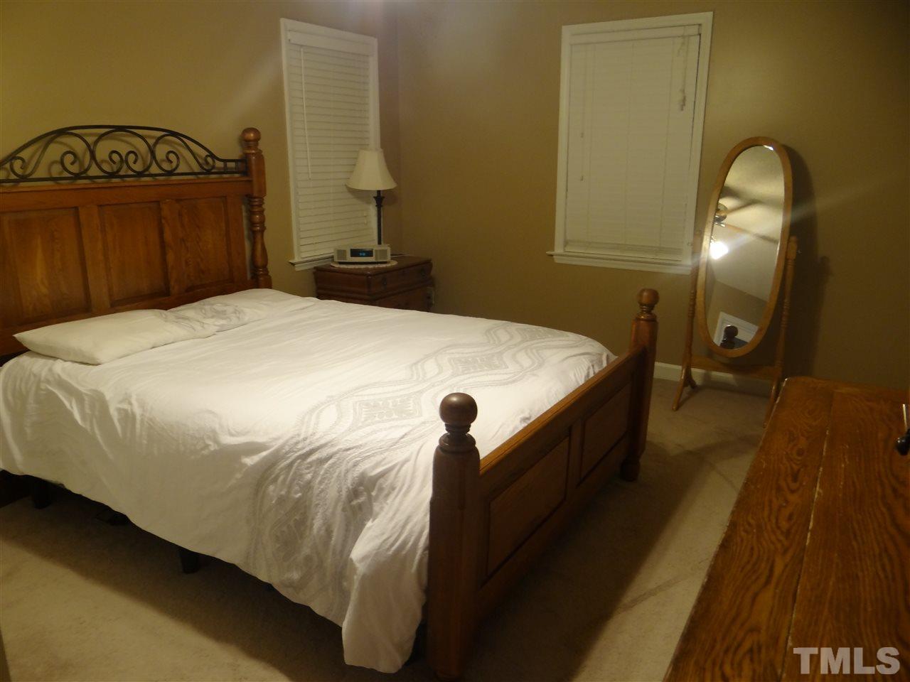 4208 Wolftrap Road Raleigh, NC 27616 - Photo 16 of 23 a bedroom with a bed and a mirror